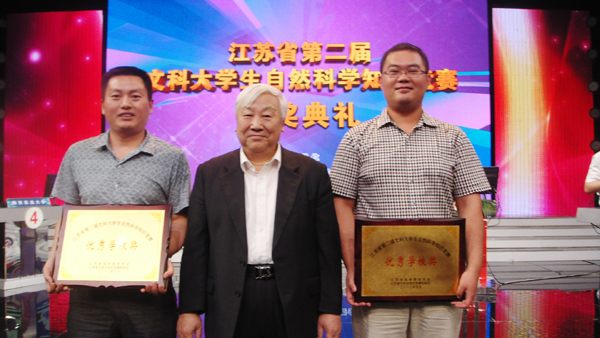 图为中国高等教育学会会长周远清与我校教师（右一）合影